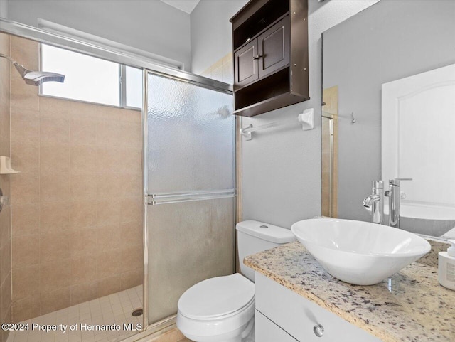 bathroom with vanity, toilet, and a shower with door