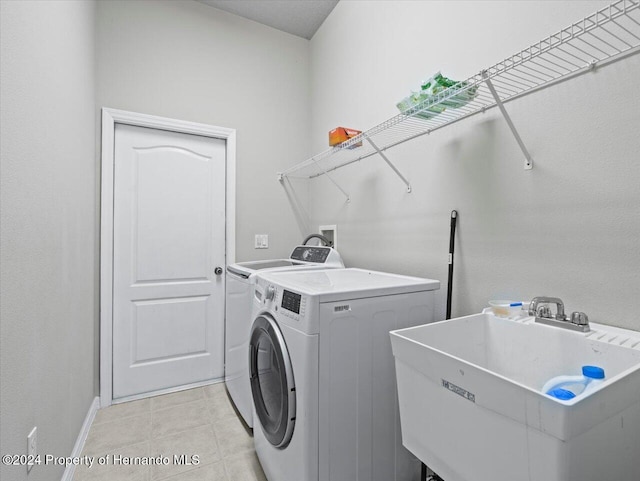 laundry room featuring separate washer and dryer, sink, and light tile patterned floors