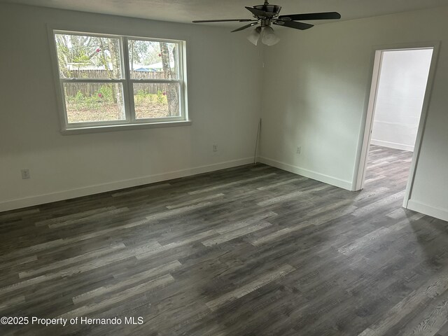 empty room featuring ceiling fan and dark hardwood / wood-style flooring