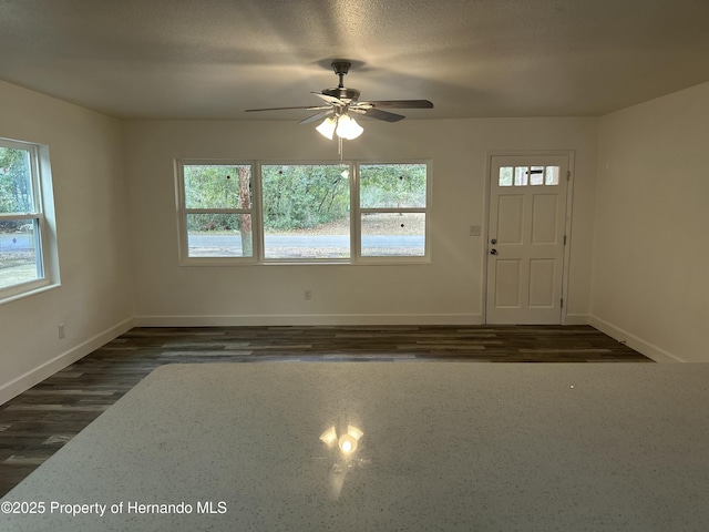 foyer entrance with ceiling fan, dark hardwood / wood-style flooring, and a textured ceiling