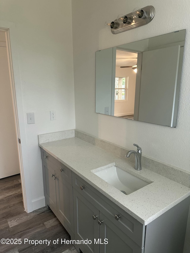 bathroom with ceiling fan, vanity, and hardwood / wood-style flooring