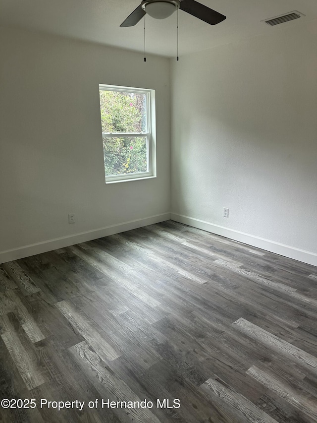 spare room featuring ceiling fan and dark hardwood / wood-style flooring