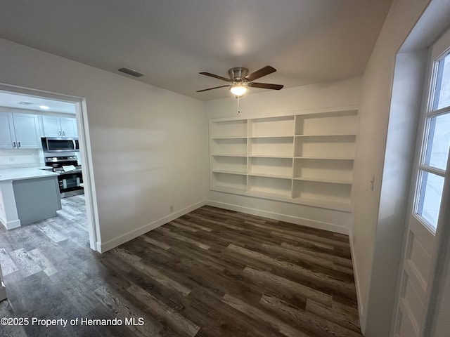 unfurnished room with ceiling fan and dark wood-type flooring