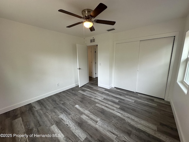 unfurnished bedroom with ceiling fan, a closet, and dark hardwood / wood-style floors