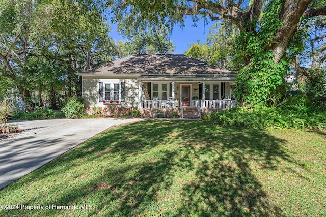 ranch-style house with covered porch and a front yard