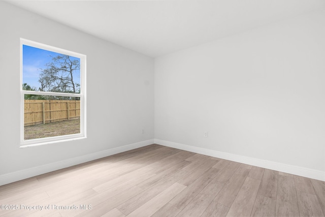 empty room with baseboards and wood finished floors