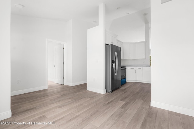 kitchen with baseboards, white cabinets, light countertops, light wood-type flooring, and stainless steel refrigerator with ice dispenser