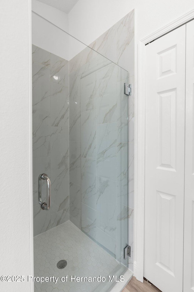 bathroom with a marble finish shower