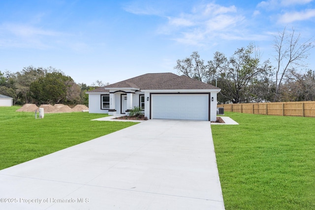 view of front of property featuring a garage, a front yard, fence, and stucco siding