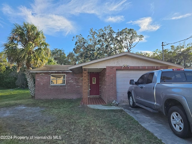 ranch-style home with a garage and a front yard