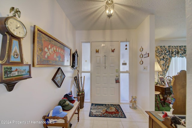 foyer entrance with light tile patterned floors and a textured ceiling