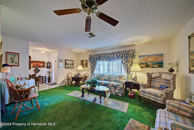 carpeted living room featuring ceiling fan and a textured ceiling