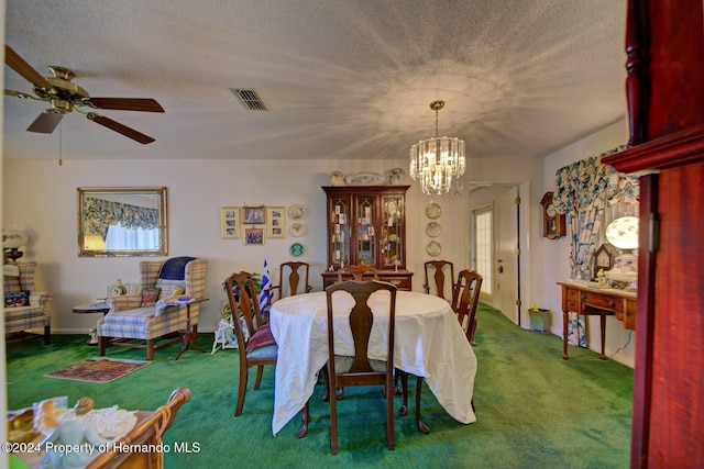 dining area with carpet flooring, ceiling fan with notable chandelier, and a textured ceiling