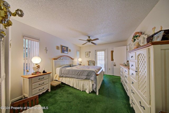 bedroom with a textured ceiling, dark carpet, and ceiling fan