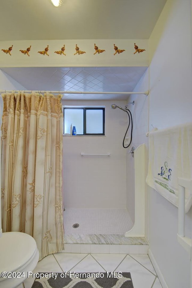 bathroom featuring toilet, tile patterned flooring, and walk in shower