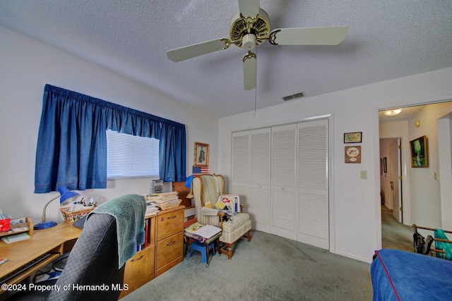 carpeted office featuring ceiling fan and a textured ceiling