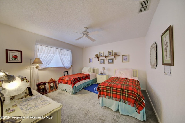 carpeted bedroom featuring ceiling fan and a textured ceiling