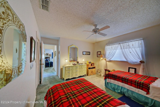 bedroom featuring carpet flooring, ceiling fan, and a textured ceiling