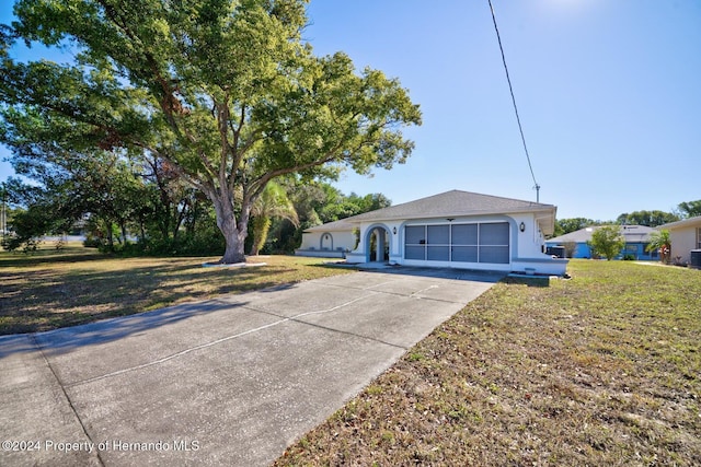 ranch-style house with a garage and a front lawn