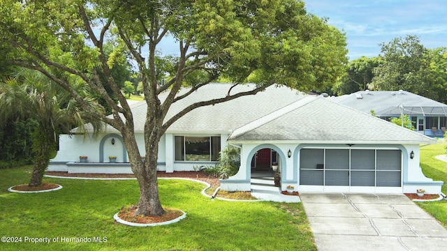 view of front of property featuring a garage and a front lawn