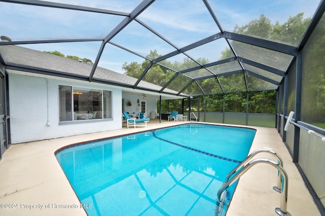 view of swimming pool featuring a lanai, ceiling fan, and a patio