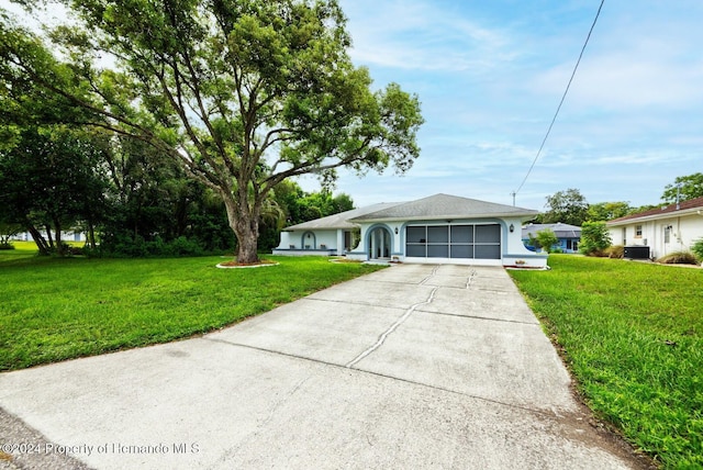 ranch-style home featuring a front yard, central AC, and a garage