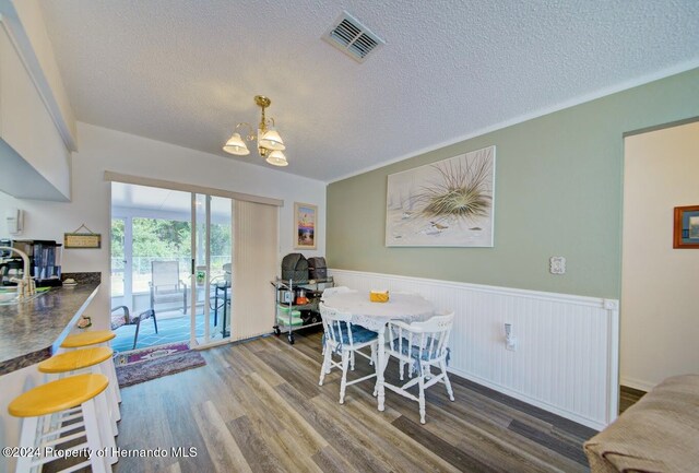 dining room featuring a chandelier, a textured ceiling, and hardwood / wood-style flooring