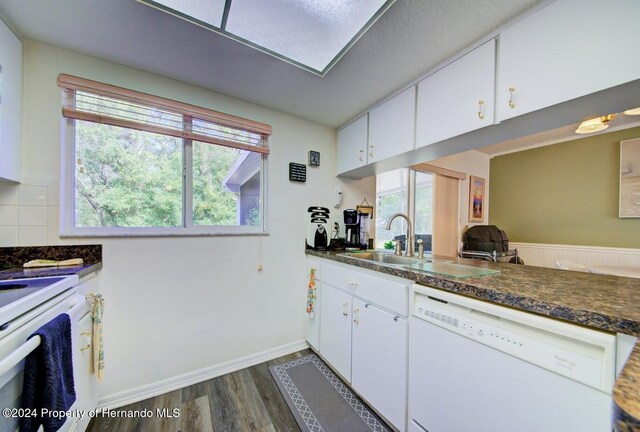 kitchen featuring a wealth of natural light, white cabinetry, dark hardwood / wood-style floors, and white appliances