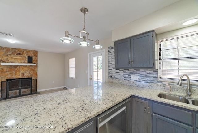 kitchen with dishwasher, a wealth of natural light, sink, and decorative light fixtures