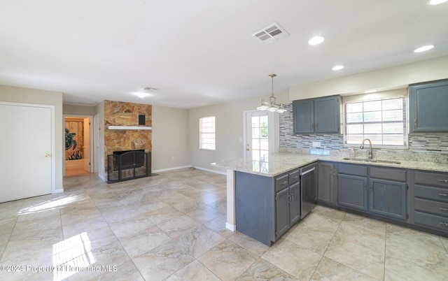 kitchen with pendant lighting, sink, stainless steel dishwasher, tasteful backsplash, and kitchen peninsula