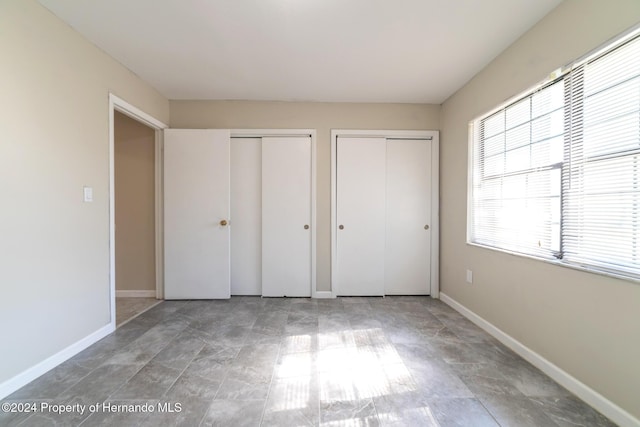 unfurnished bedroom with multiple closets