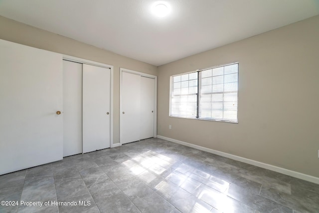 unfurnished bedroom with multiple closets