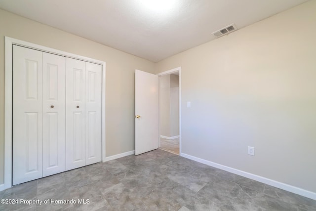 unfurnished bedroom featuring a textured ceiling and a closet