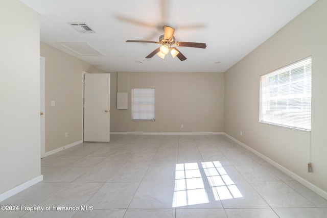 tiled spare room featuring ceiling fan