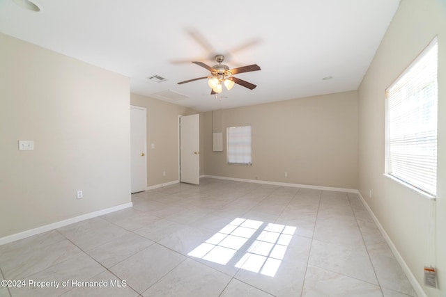 tiled spare room featuring ceiling fan