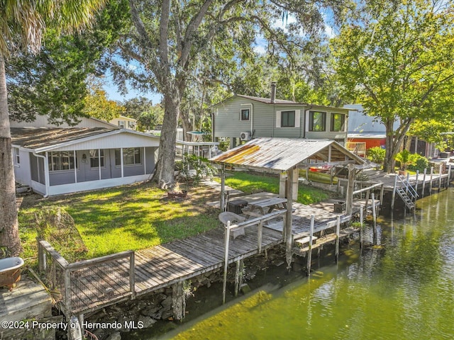 dock area with a lawn and a water view