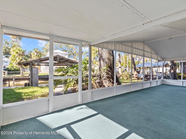 unfurnished sunroom featuring plenty of natural light and vaulted ceiling