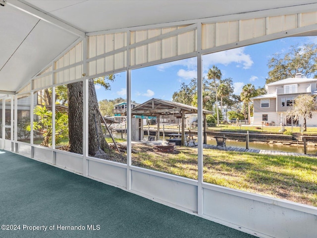 sunroom / solarium featuring a water view and vaulted ceiling