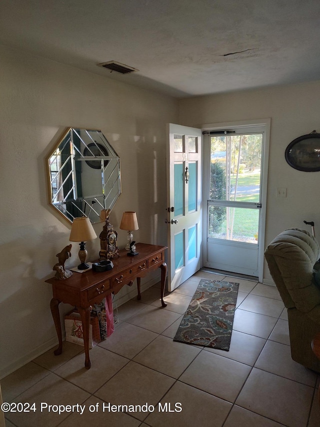 doorway to outside with light tile patterned floors