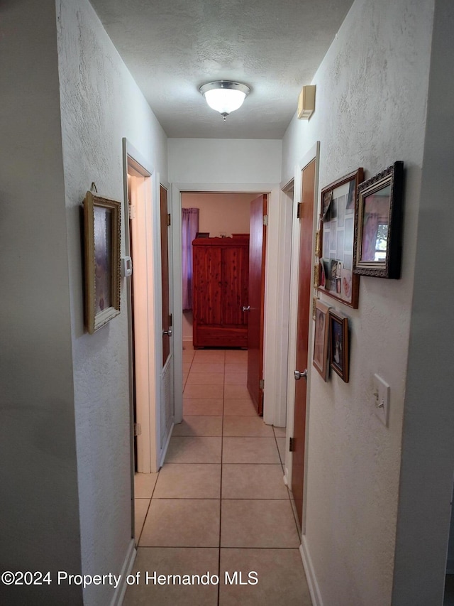 hall with light tile patterned floors