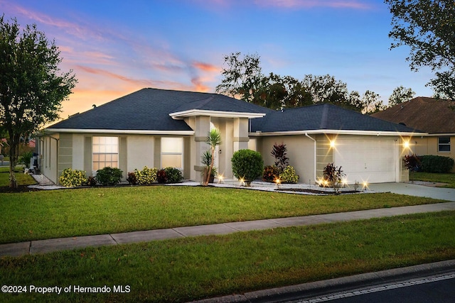 view of front of property featuring a lawn and a garage