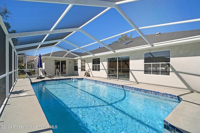 view of swimming pool featuring a patio area and a lanai