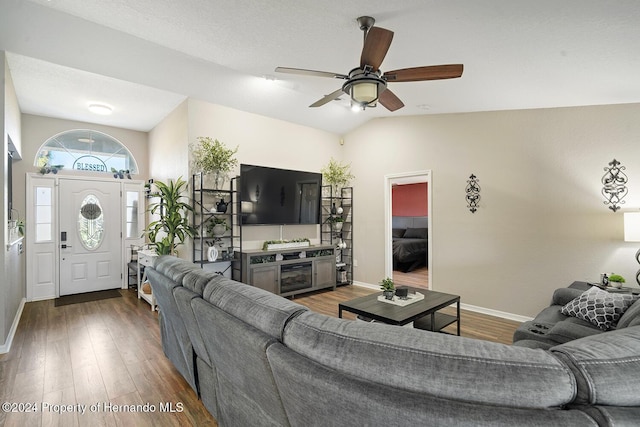 living room with ceiling fan, dark hardwood / wood-style flooring, lofted ceiling, and a textured ceiling