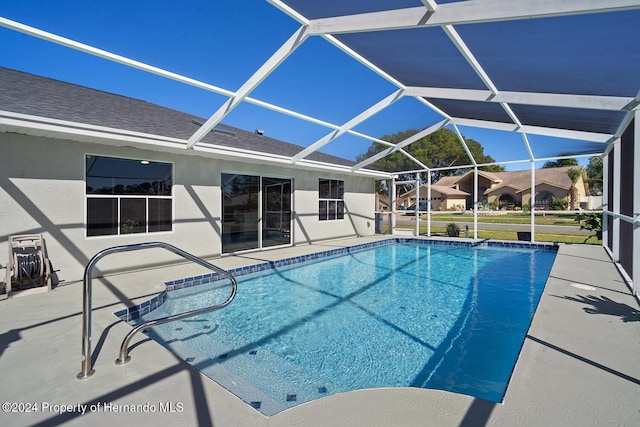 view of pool with a patio area and a lanai