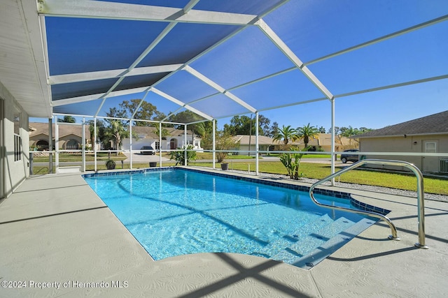 view of swimming pool featuring a patio area and a lanai