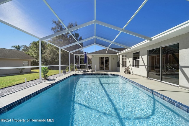 view of pool featuring glass enclosure and a patio