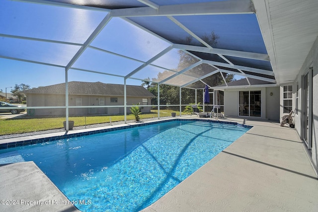 view of swimming pool featuring a lanai, a patio area, and a yard