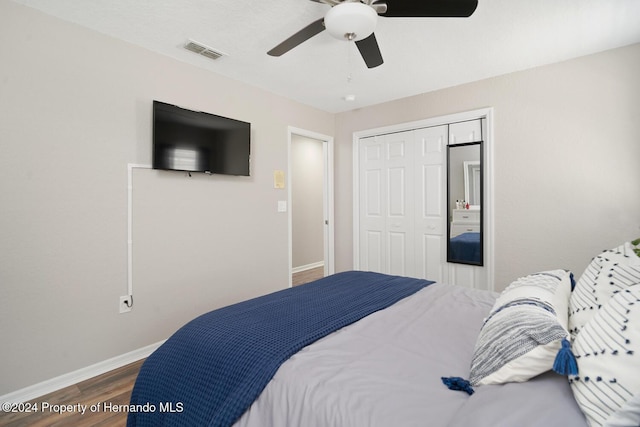 bedroom with ceiling fan, wood-type flooring, and a closet