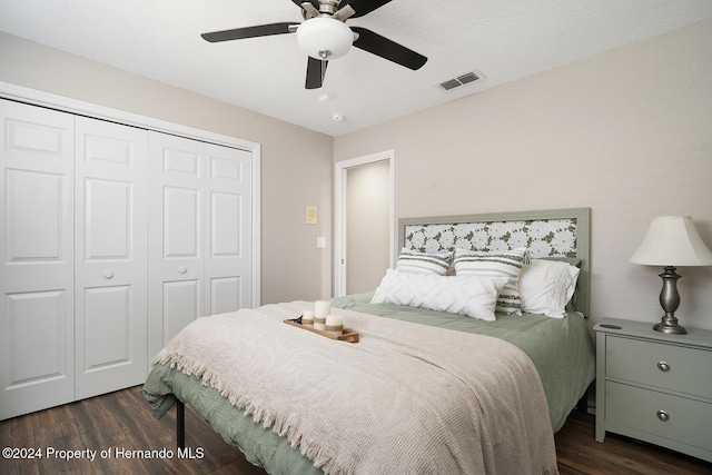 bedroom featuring ceiling fan, a closet, dark wood-type flooring, and a textured ceiling