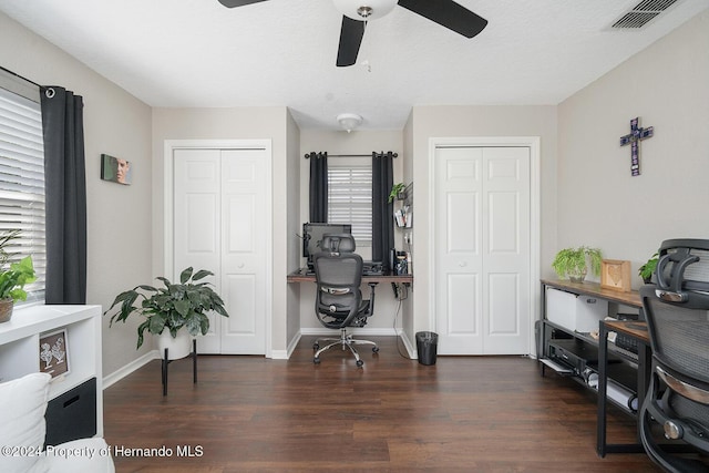 home office with ceiling fan and dark wood-type flooring